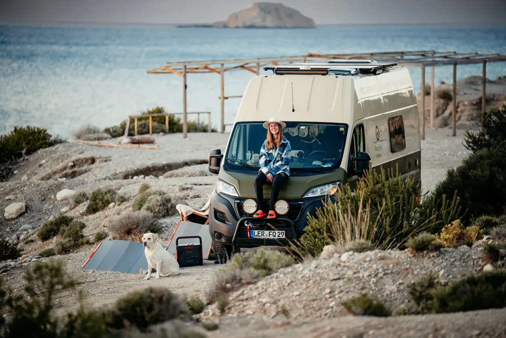 FeuerQuell Fotografie on Tour Tomke sitzt auf dem Van am Strand