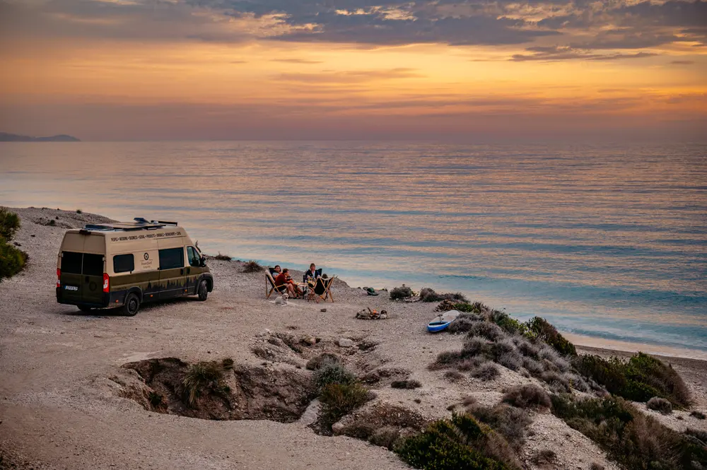 FeuerQuell on tour am strand mit Meer im Hintergrund, Van und Menschen